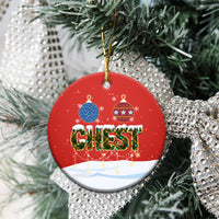 Red ceramic round Christmas ornament with gold loop, “CHEST” nut scene hanging on a tree