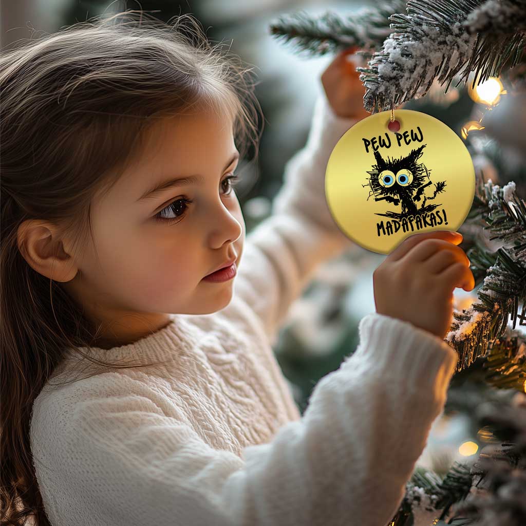 Gold round cat Christmas ornament with 'PEW PEW MADAFakasi' text, hanging on tree