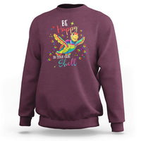 Maroon crewneck sweatshirt with colorful turtle shell graphic on front