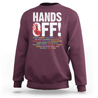 Maroon crewneck sweatshirt with “HANDS OFF!” graphic on the back