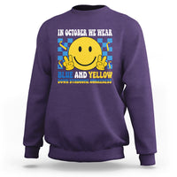 Purple sweatshirt with yellow smiley and blue-and-yellow awareness text on back.