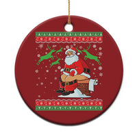 Red round Christmas ornament with Santa holding a chimney and a gold hanging string