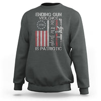Dark heather crewneck sweatshirt with patriotic gun-violence graphic and text