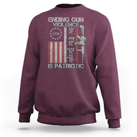 Maroon crewneck sweatshirt with patriotic gun-violence graphic and text