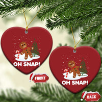 Two red heart-shaped “OH SNAP!” gingerbread ornaments hanging from gold cords