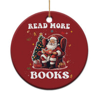 Red round Christmas ornament with Santa reading and text “READ MORE BOOKS”