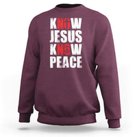 Maroon sweatshirt with 'KNOW JESUS KNOW PEACE' graphic in white/red text.