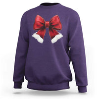 Purple crewneck sweatshirt with red bow and white pom accents on chest