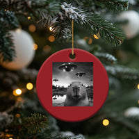 Red round Christmas ornament with capybara and UFO graphic, hanging from gold string