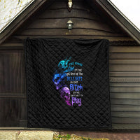 Black quilt hanging on wall with multicolor skull-and-text graphic, diamond pattern