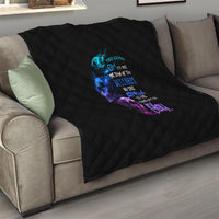 Black diamond-quilted throw blanket on couch with multicolor skull-and-text graphic