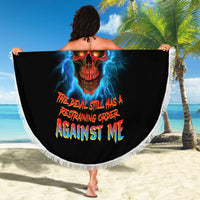 Black round beach blanket with fringed edge held out; skull with lightning and multicolor slogan