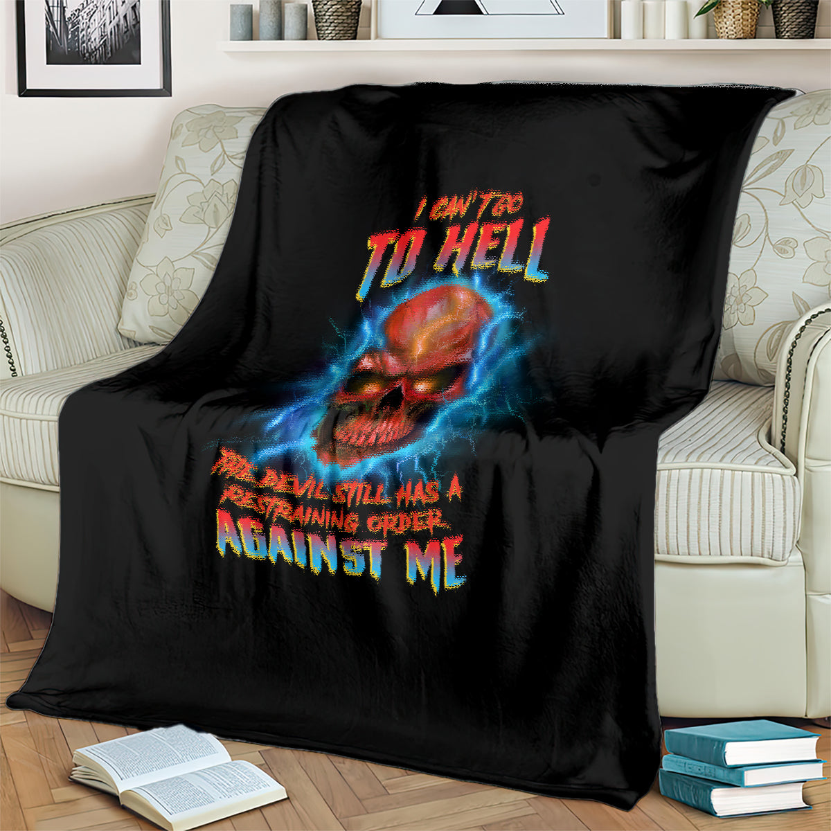 Black skull graphic throw blanket with blue lightning and multicolor slogan on striped couch