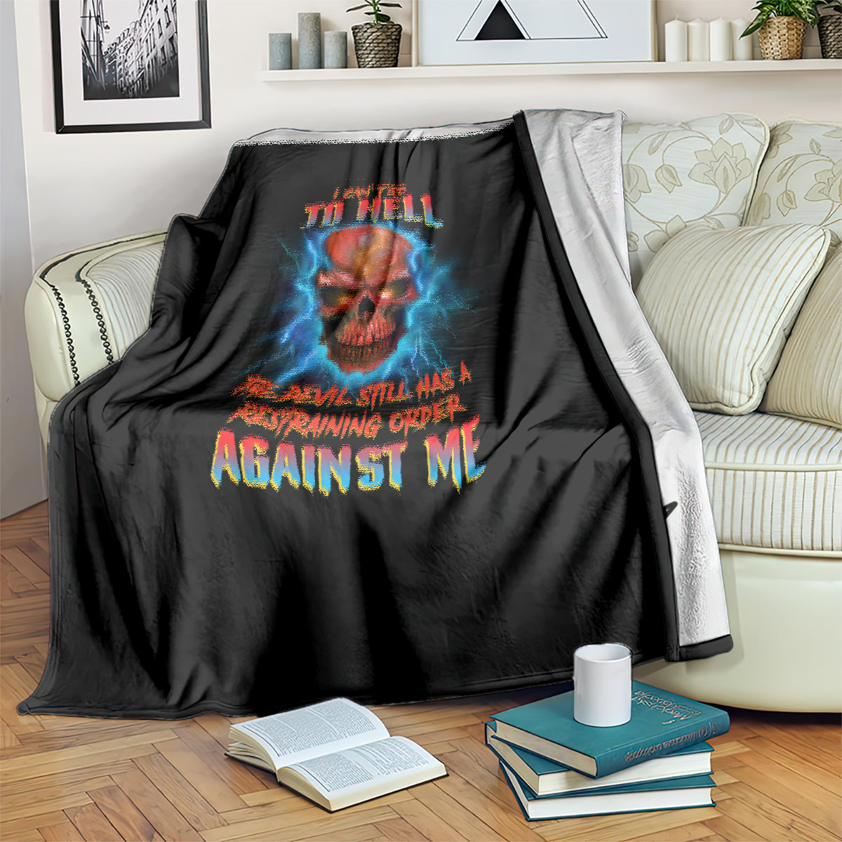 Black skull graphic blanket with blue lightning and multicolor text, draped over arm of chair
