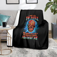 Black skull graphic throw blanket with blue lightning and red-yellow slogan, on couch