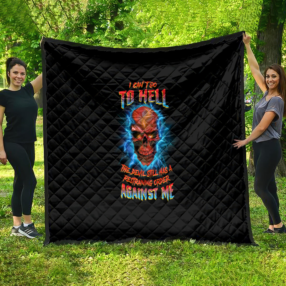Black quilt blanket with diamond quilting and colorful skull graphic, statement text center