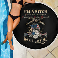 Round black beach blanket with fringed border, shown with skull crossbones design in center.