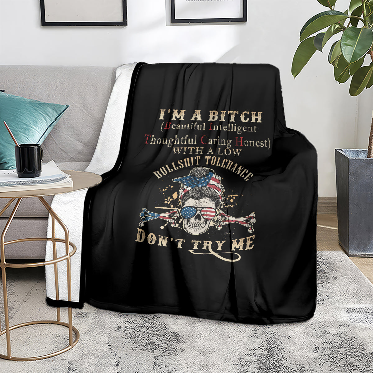Black blanket with skull graphic and 'Don't Try Me' text on sofa with pillows