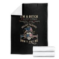 Black blanket with skull graphic and text, folded with stacked white towels