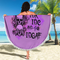 Round purple beach blanket with fringed edge, skull-rose design and bold 'Stuck Between' text