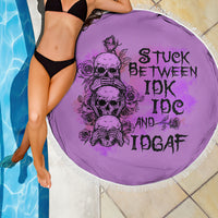 Round purple beach blanket with fringed edge, skull-rose graphic and dark lettering
