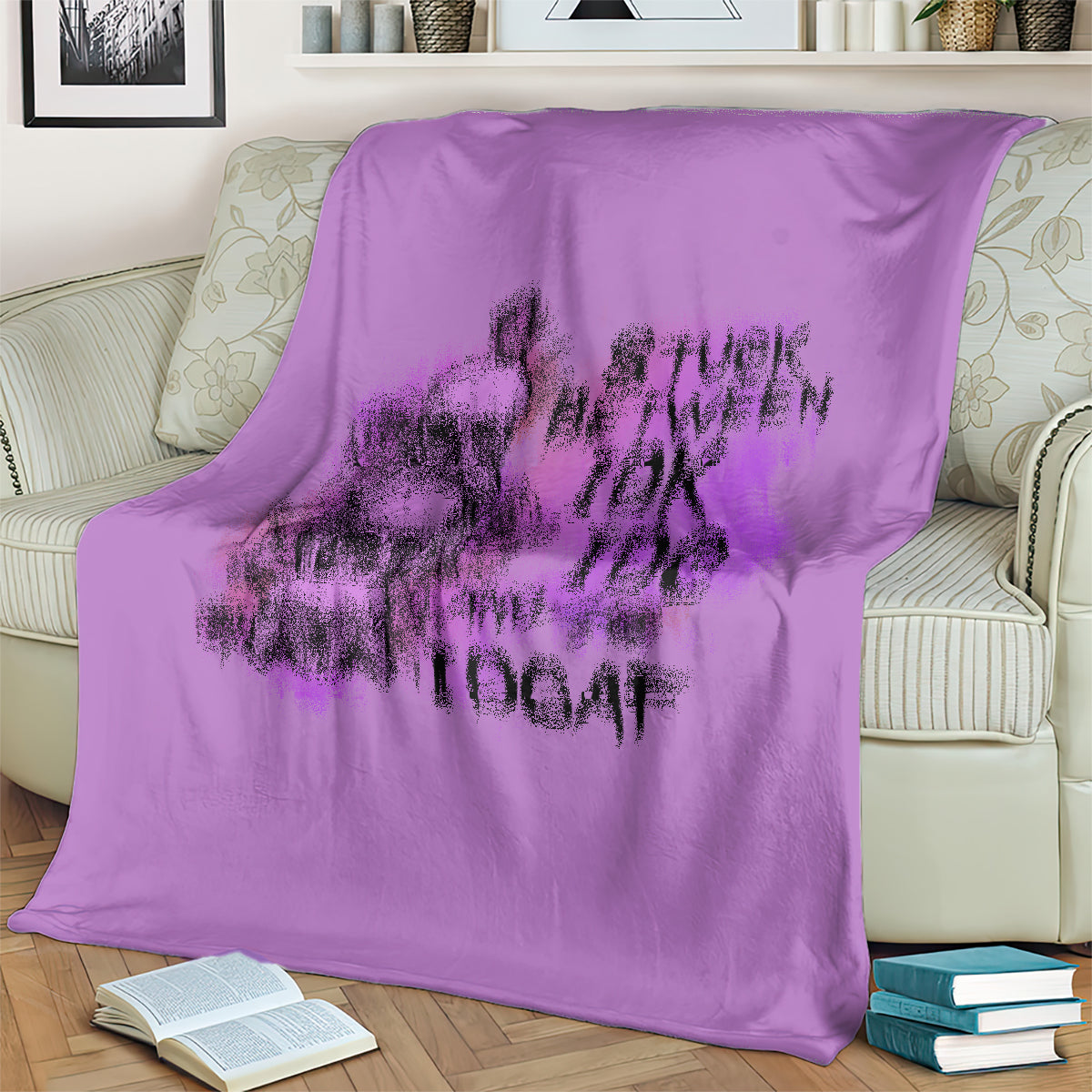 Purple graphic blanket with large blurred skull-and-text motif, laid over bed