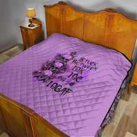 Purple quilt with diamond quilting and black graphic print on bed