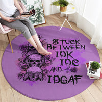 Purple round rug with black skull-and-roses graphic and 'STUCK BETWEEN IDK IDGAF' text