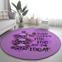 Purple round rug angled view with black skull-and-roses graphic and 'STUCK BETWEEN IDK IDGAF' text