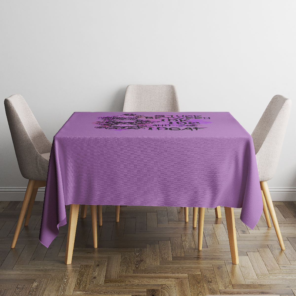Purple tablecloth on small dining table with four upholstered chairs.