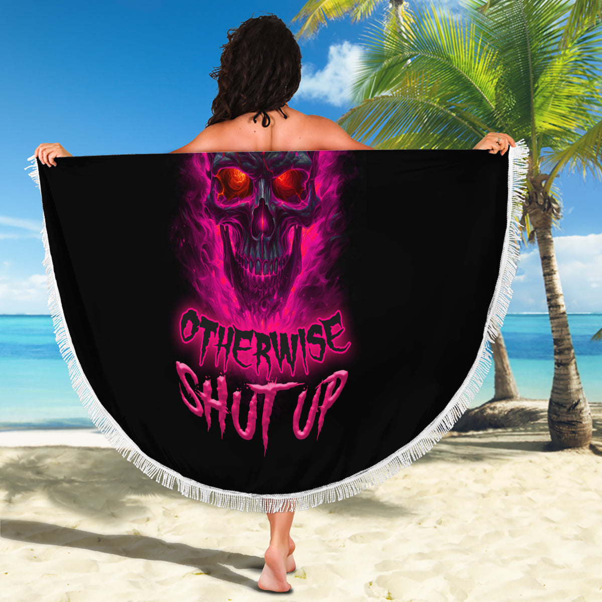 Round beach blanket held up, black with purple skull artwork and white fringe trim