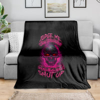 Black fleece blanket with purple skull graphic and slogan print, draped on a sofa