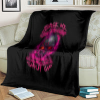 Black blanket with large purple skull graphic on front, folded on a couch