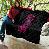 Black quilt with pink skull graphic, diamond quilt pattern draped on sofa