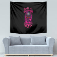 Black tapestry wall hanging with purple skull and text design, centered above a light sofa