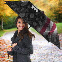 Black patterned umbrella with red-white-blue flag panel and angled vertical TEAM text