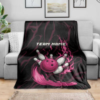 Black and pink flaming bowling ball and pins graphic blanket on gray sofa