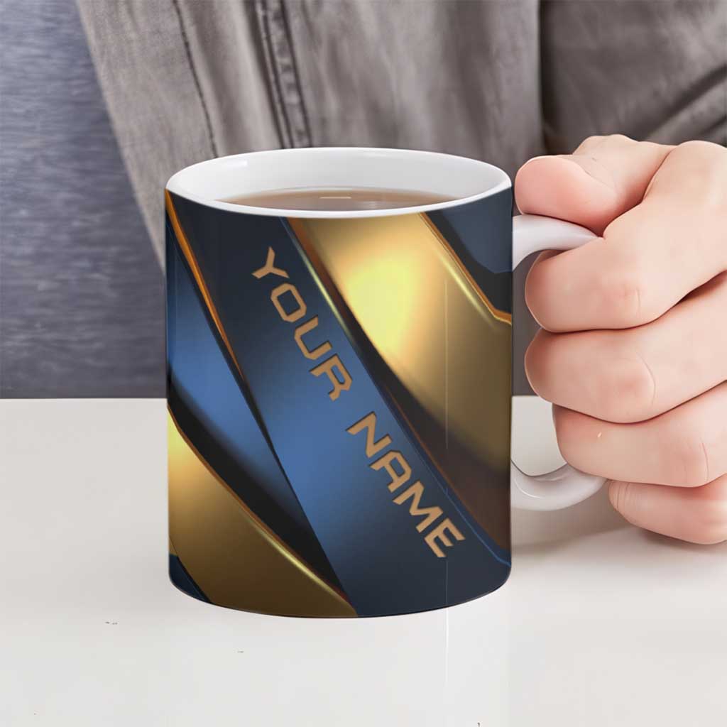 Ceramic mug with blue and gold bowling graphic, held by hand
