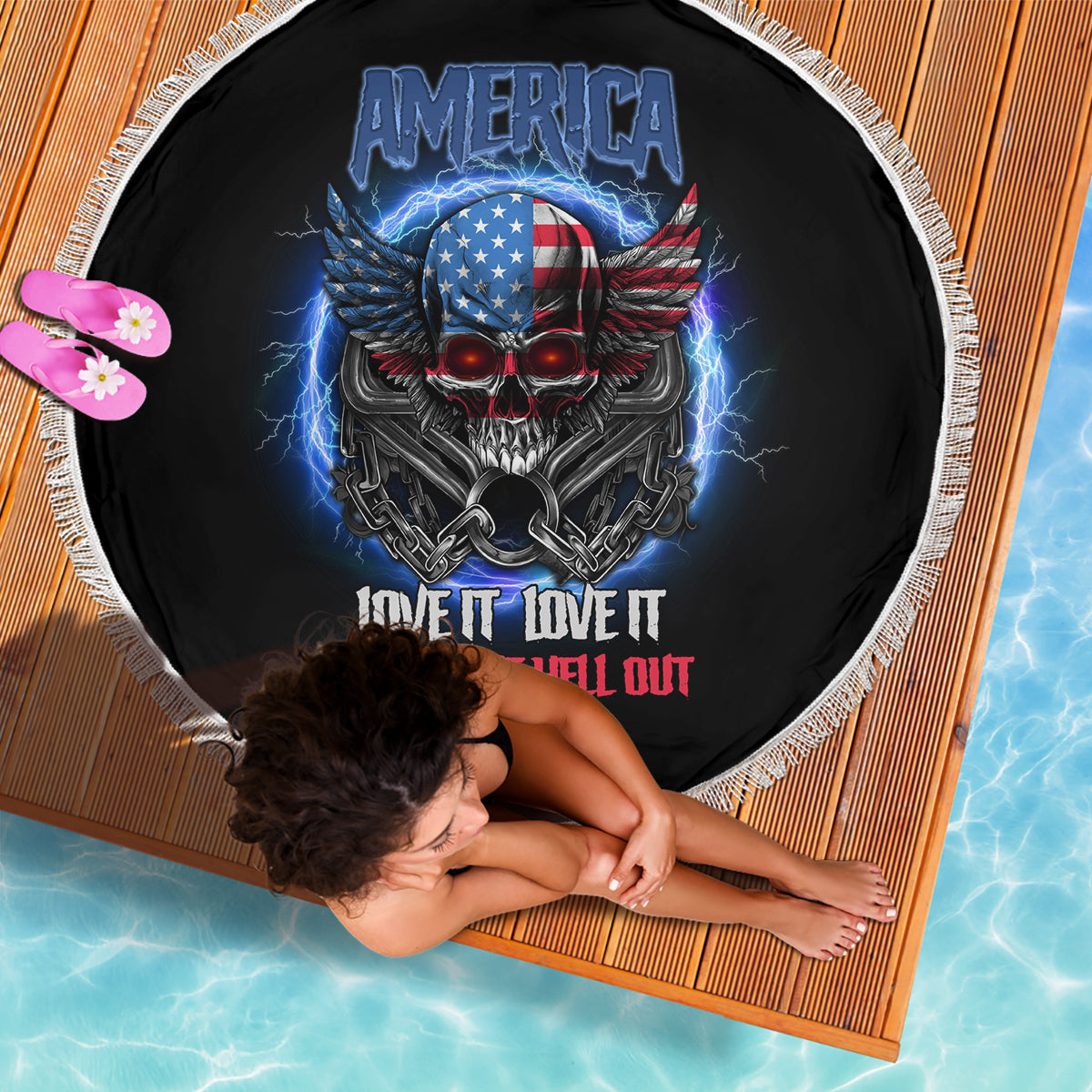 Round black beach blanket with white fringe, America skull and wings graphic, text design.