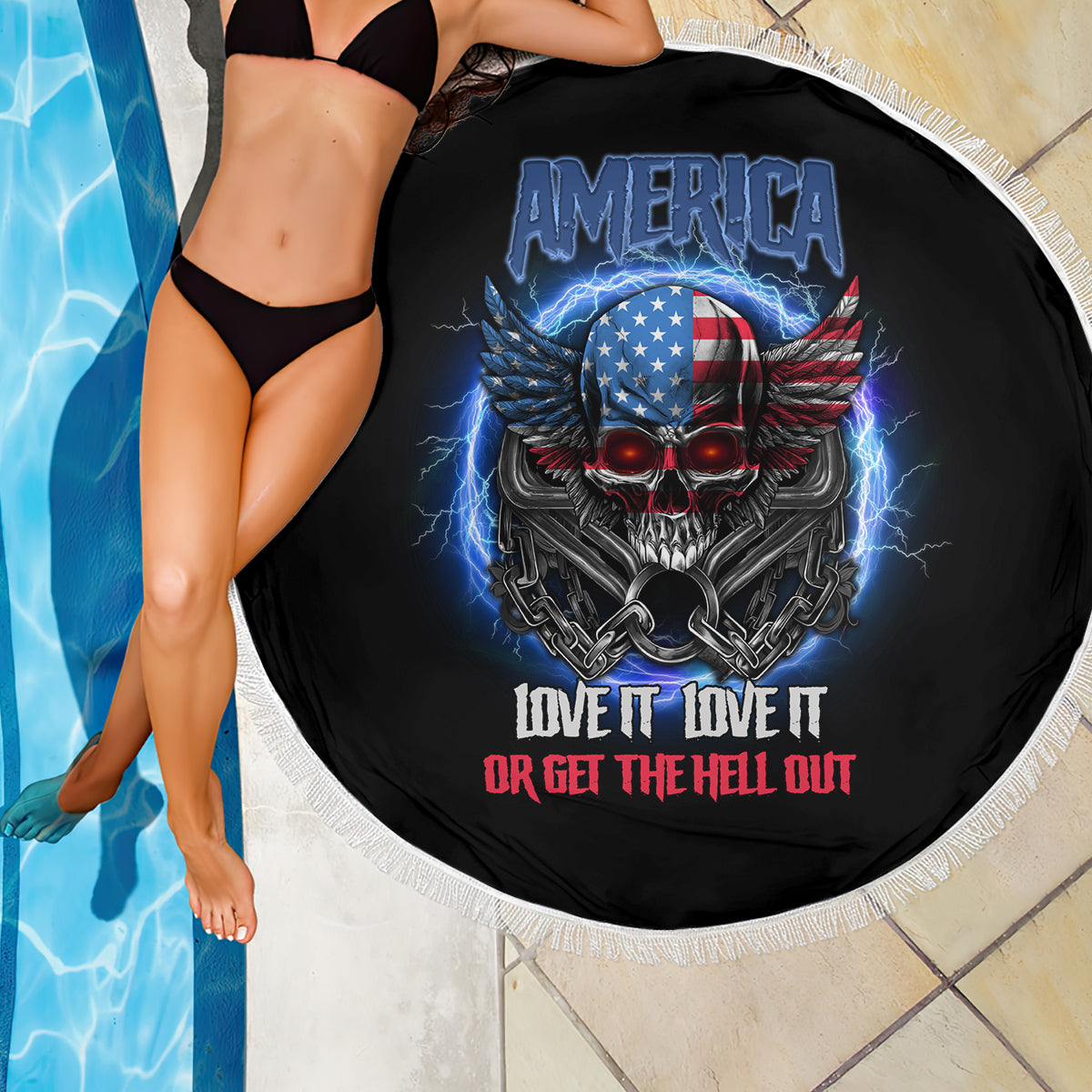 Round black beach blanket with white fringe, America skull wings graphic and red/white slogan.