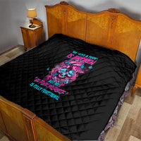 Black quilt laid on bed, neon skull and text graphic with quilted diamond stitching