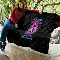 Black quilt draped on couch, neon skull and text graphic with quilted diamond stitching