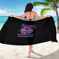 Black sarong with colorful skull graphic and text print, draped wide.
