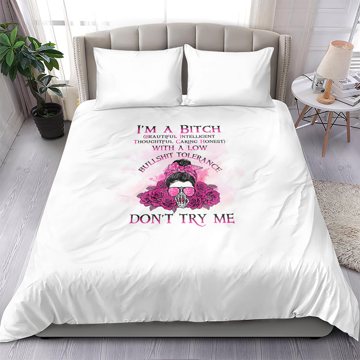 White bedding set with pink skull-and-flowers graphic, bold text on duvet, two pillowcases