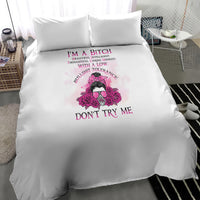 White duvet cover with pink skull-and-flowers graphic and bold 'DON'T TRY ME' text, two pillows