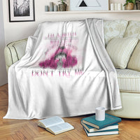 White blanket on sofa with pink floral skull graphic, visible edge and folded into throws.