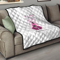 White quilt with diamond quilting and pink rose character graphic displayed on a sofa.