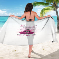 White sarong with purple rose graphic and bold text, held wide as a beach wrap.