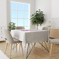 White tablecloth with multicolor rose and text design at the table’s center