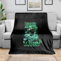 Black blanket with green reaper skull graphic, draped over a sofa